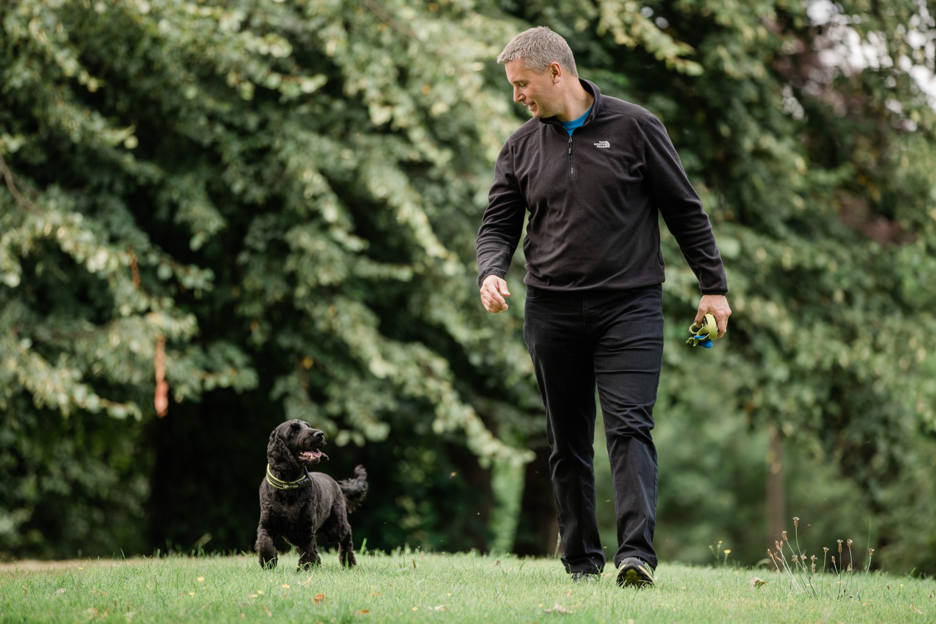 Andy Griffiths looking down at his dog on a walk