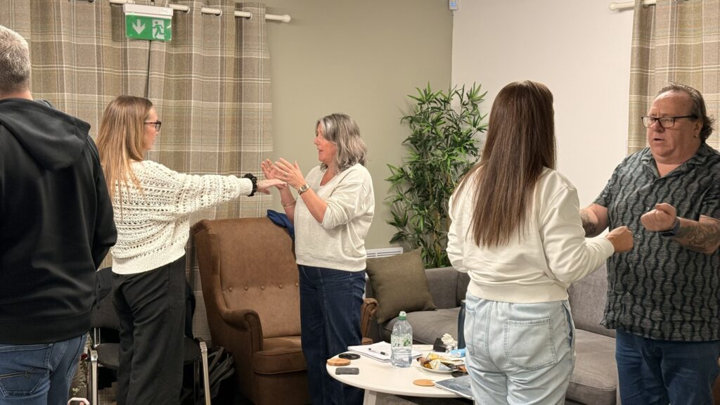 Students practising hypnotherapy techniques in pairs during classroom training in Glasgow