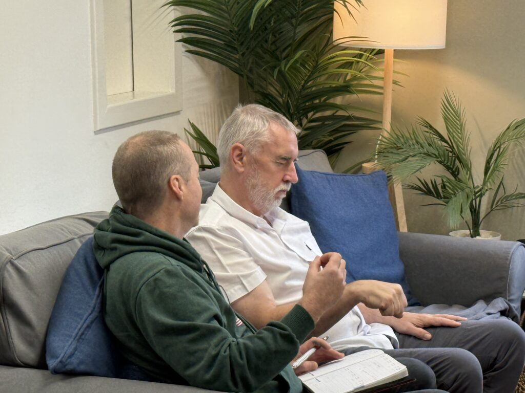 A hypnotherapy student guiding a fellow student through a practice session in Glasgow