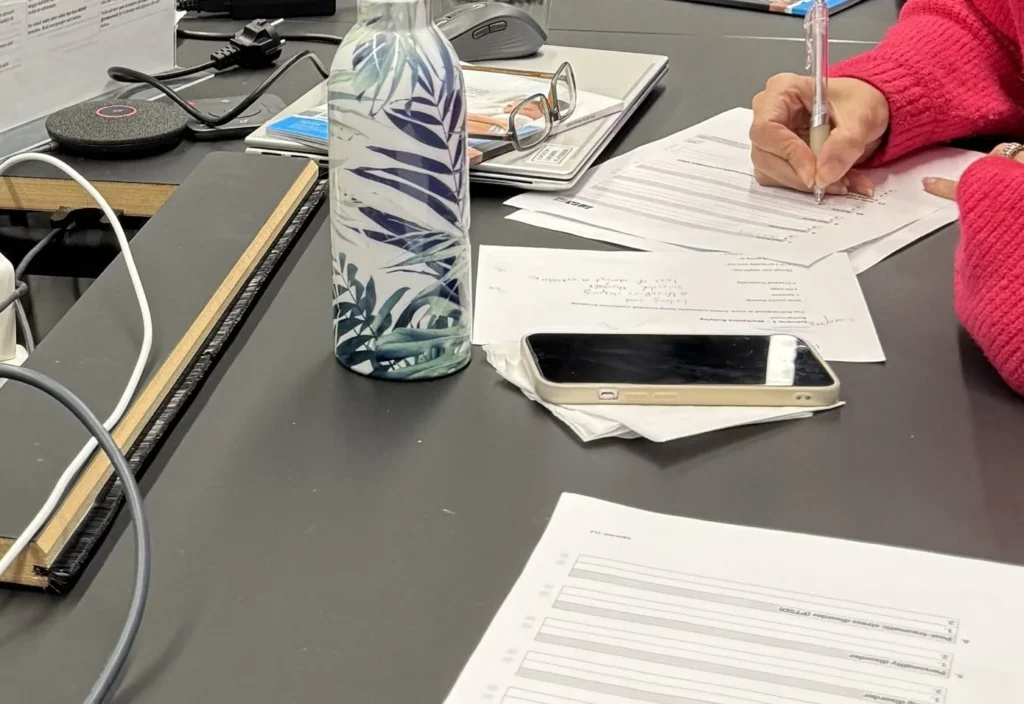 Notes and course materials on the table during a mental health training session